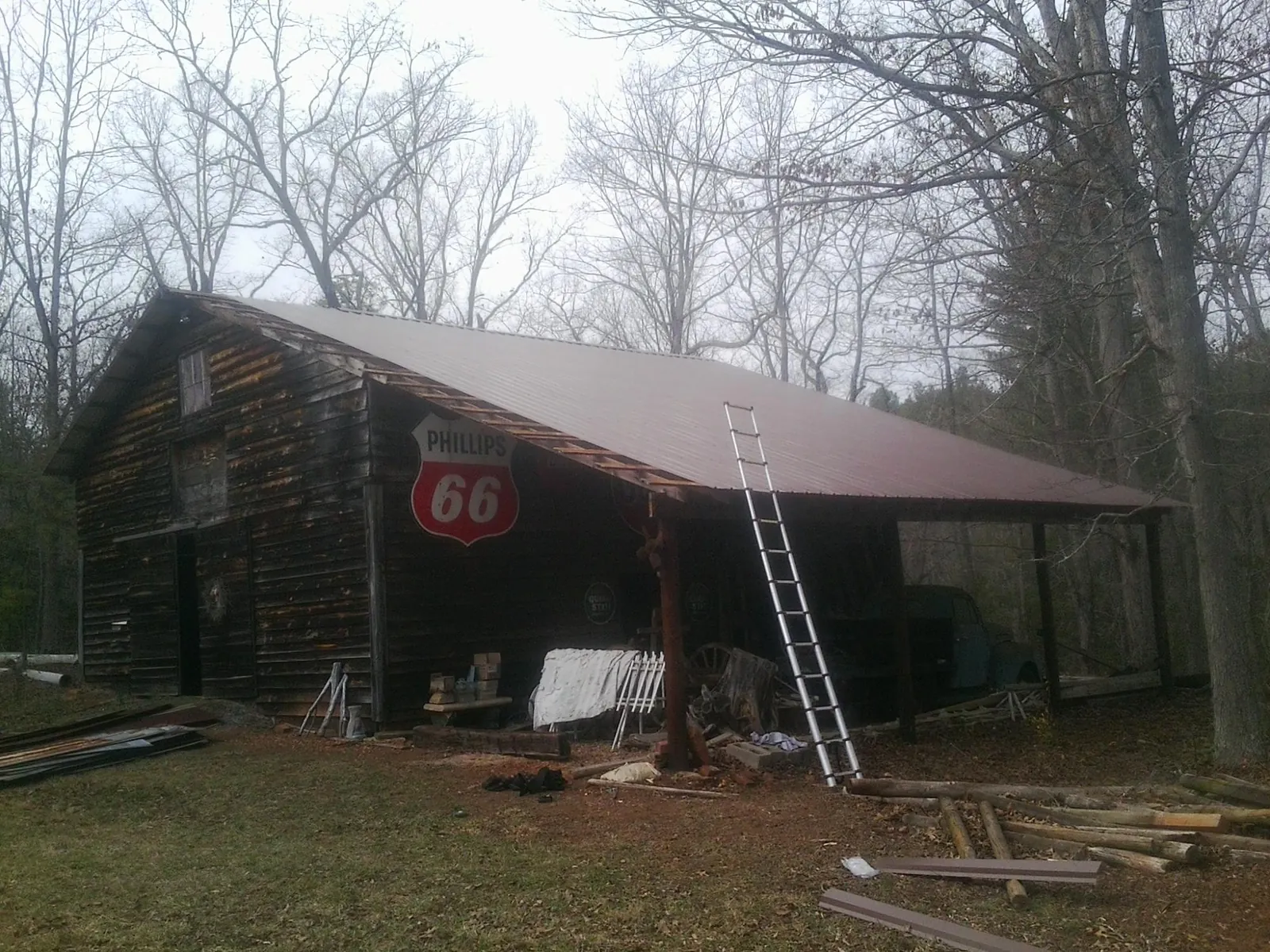 New metal roof on an open sided timber barn with a vintage sign in Tuskegee