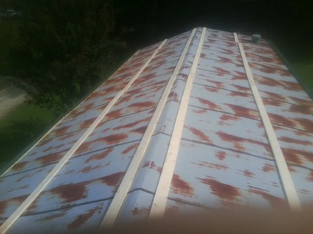 Rusted metal roof panels with new wood purlins before replacement — Storm Damage Roof Repair in Tuskegee by Roofing Brothers
