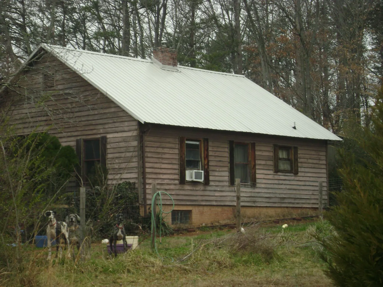 White metal roof on an old wood sided farmhouse, from a Metal Roof Installation job in Tuskegee